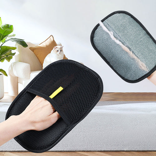 Black mesh glove wiping a grey sofa, with a line of pet hair gathered on the fabric side